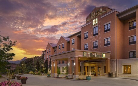 A brick building with a sign reading "The Inn" and "Franciscan Square".