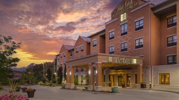 A brick building with a sign reading "The Inn" and "Franciscan Square".