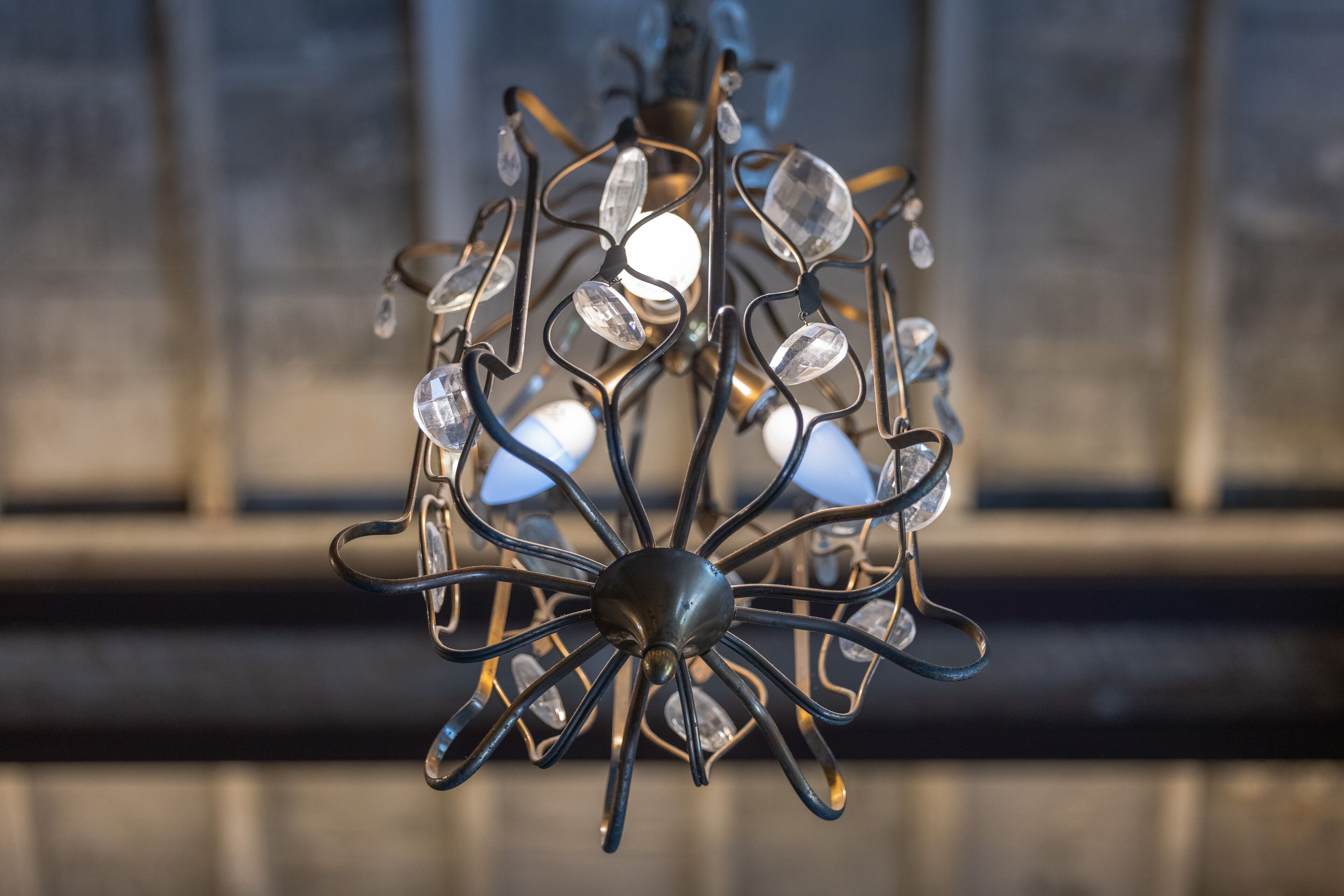 A chandelier with multiple crystal elements and a central metallic structure.