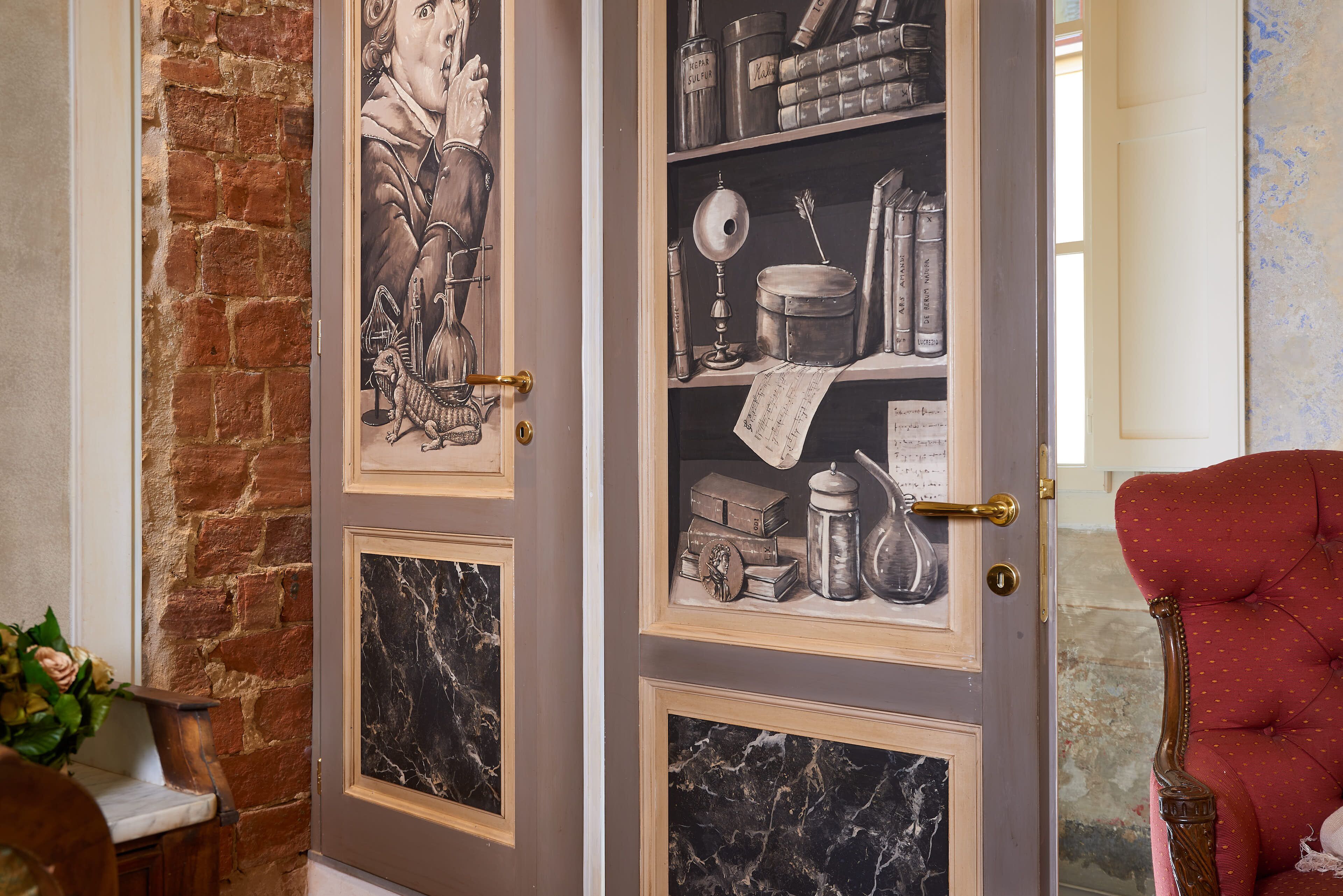 A room with a marble-patterned door, a red upholstered chair, and a brick wall.