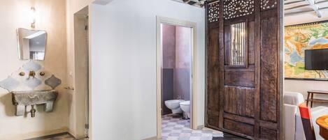 Un baño con lavabo, espejo e inodoro.