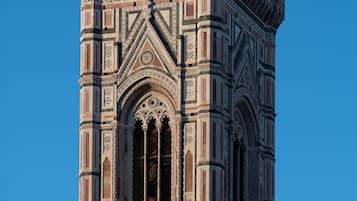 Una torre alta y ricamente decorada, con ventanas en arco y diseños ornamentales.