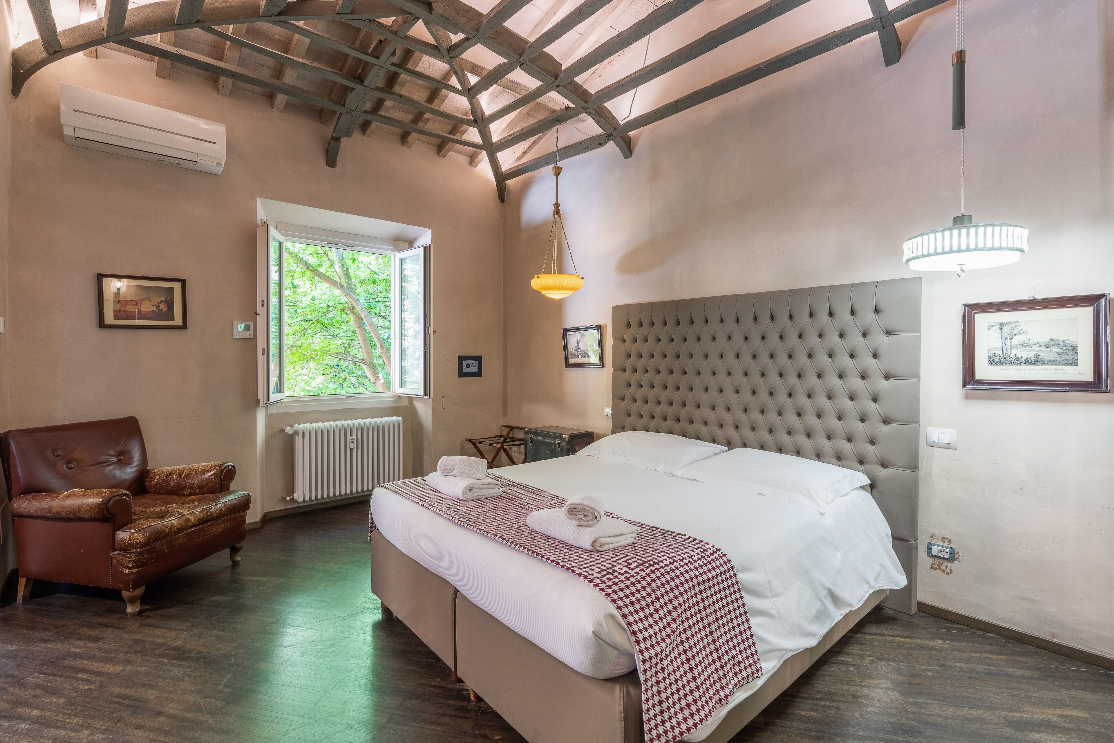 Un dormitorio con una cama grande, una silla, una ventana y un ventilador de techo.