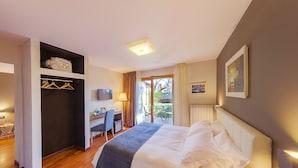 Une chambre d’hôtel équipée d’un lit, d’un bureau, d’une chaise, d’une armoire et offrant une vue sur l’extérieur.
