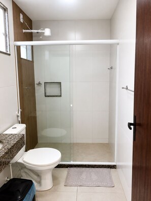 A bathroom with a shower, toilet, and sink. - Pousada Vivamar (Saquarema)