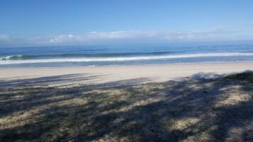 En la playa, playa de arena blanca, camastros y sombrillas