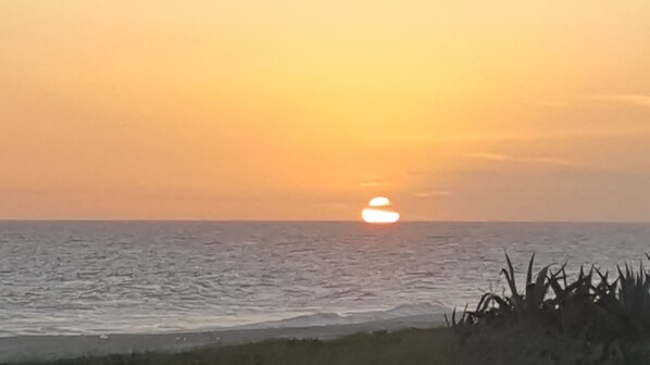 Un coucher de soleil sur l’océan, avec un horizon dégagé.