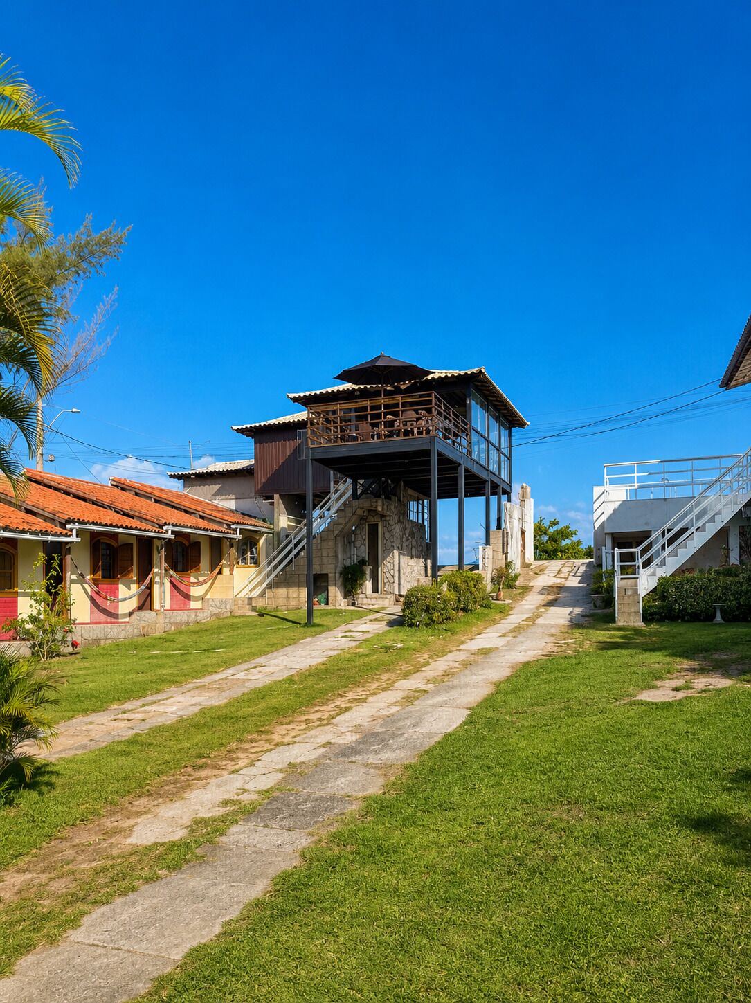 A two-story building with a balcony, a staircase, and a clear sky.