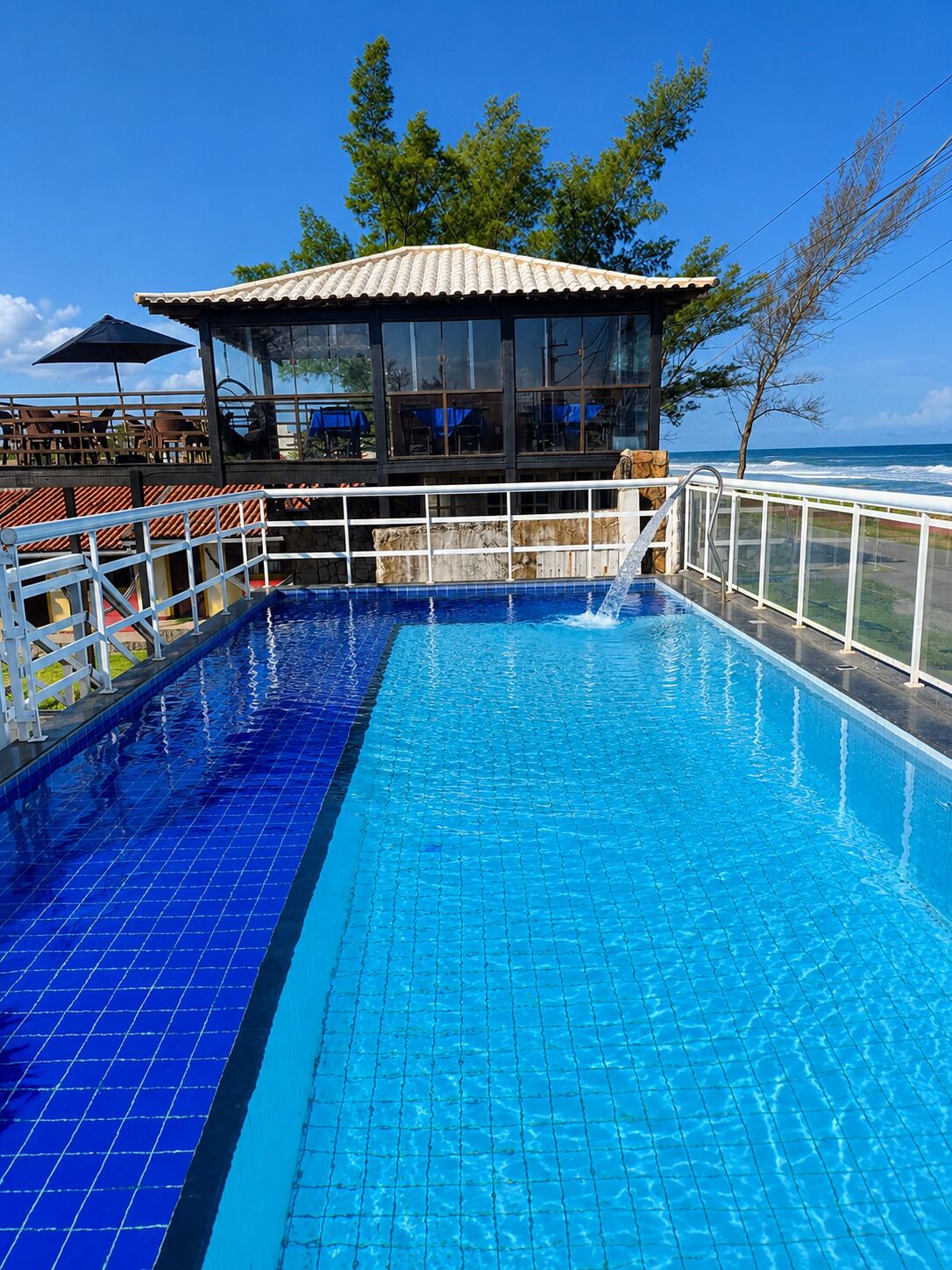 Una piscina al aire libre, sombrillas, sillones reclinables de piscina