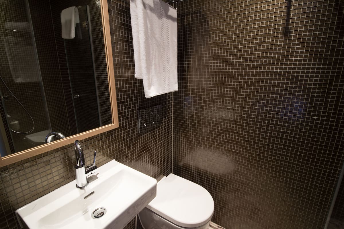 Un baño con un lavamanos blanco, un inodoro y un espejo.