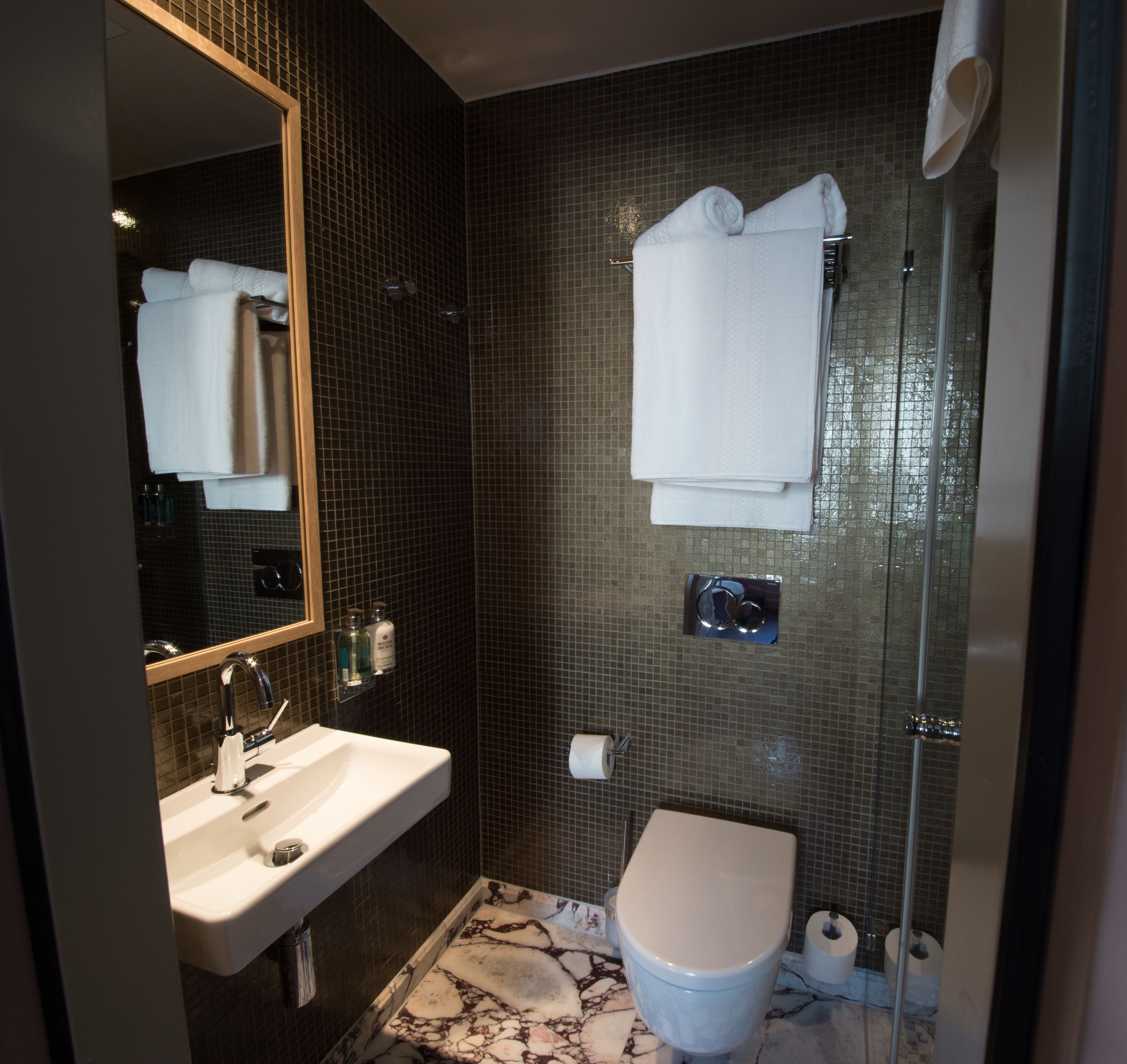 Een badkamer met een wastafel, toilet en spiegel.