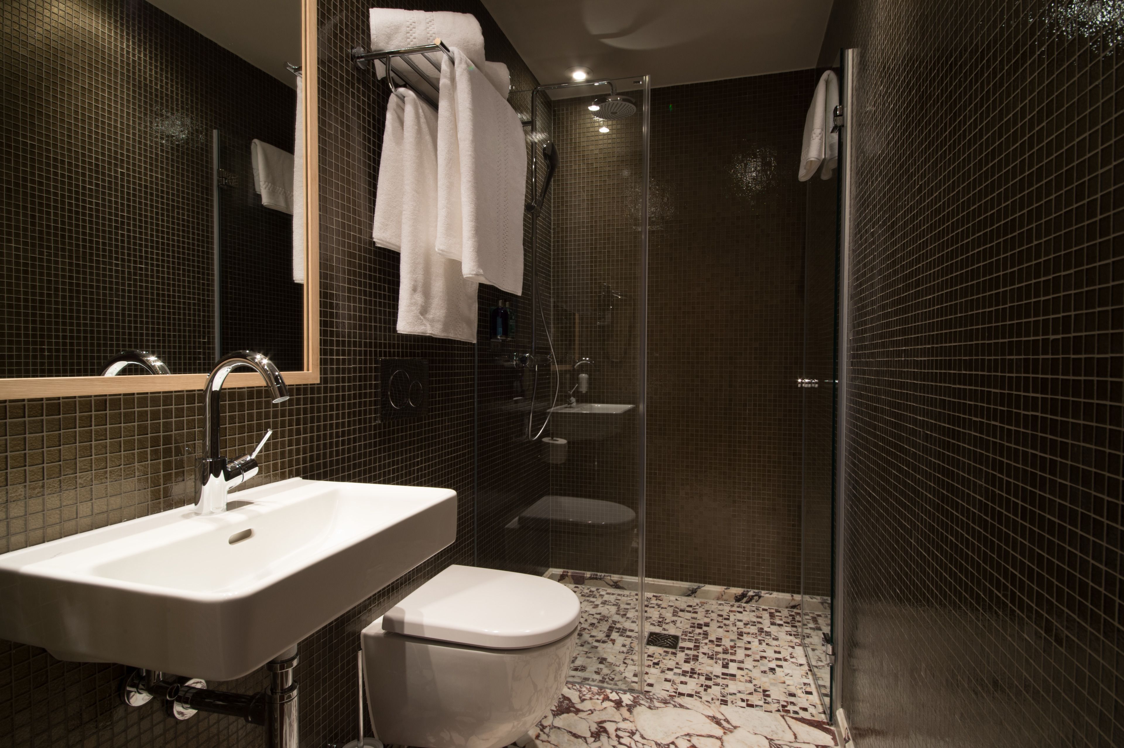 Une salle de bain moderne équipée d’un lavabo, de toilettes et d’une douche.