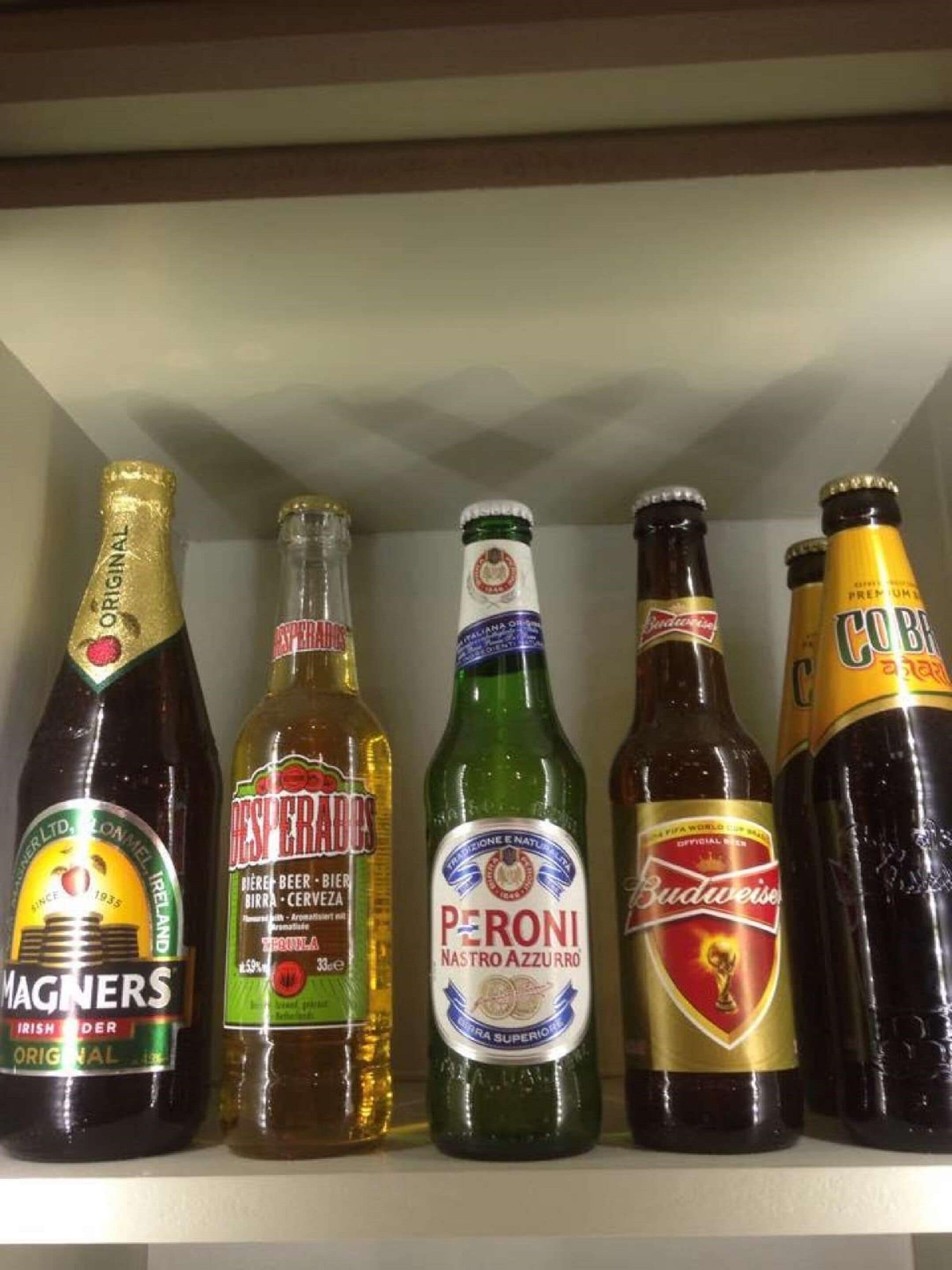 En hylla med sex flaskor alkoholhaltiga drycker.