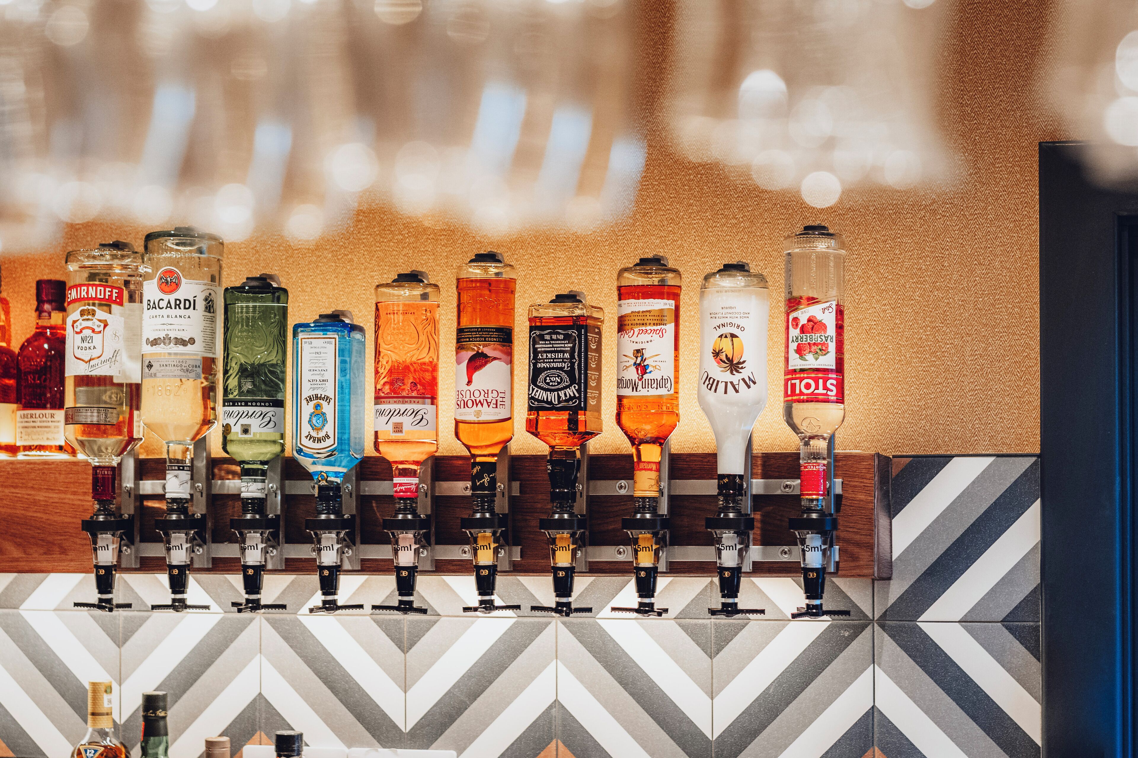 A bar with various liquor bottles and taps.