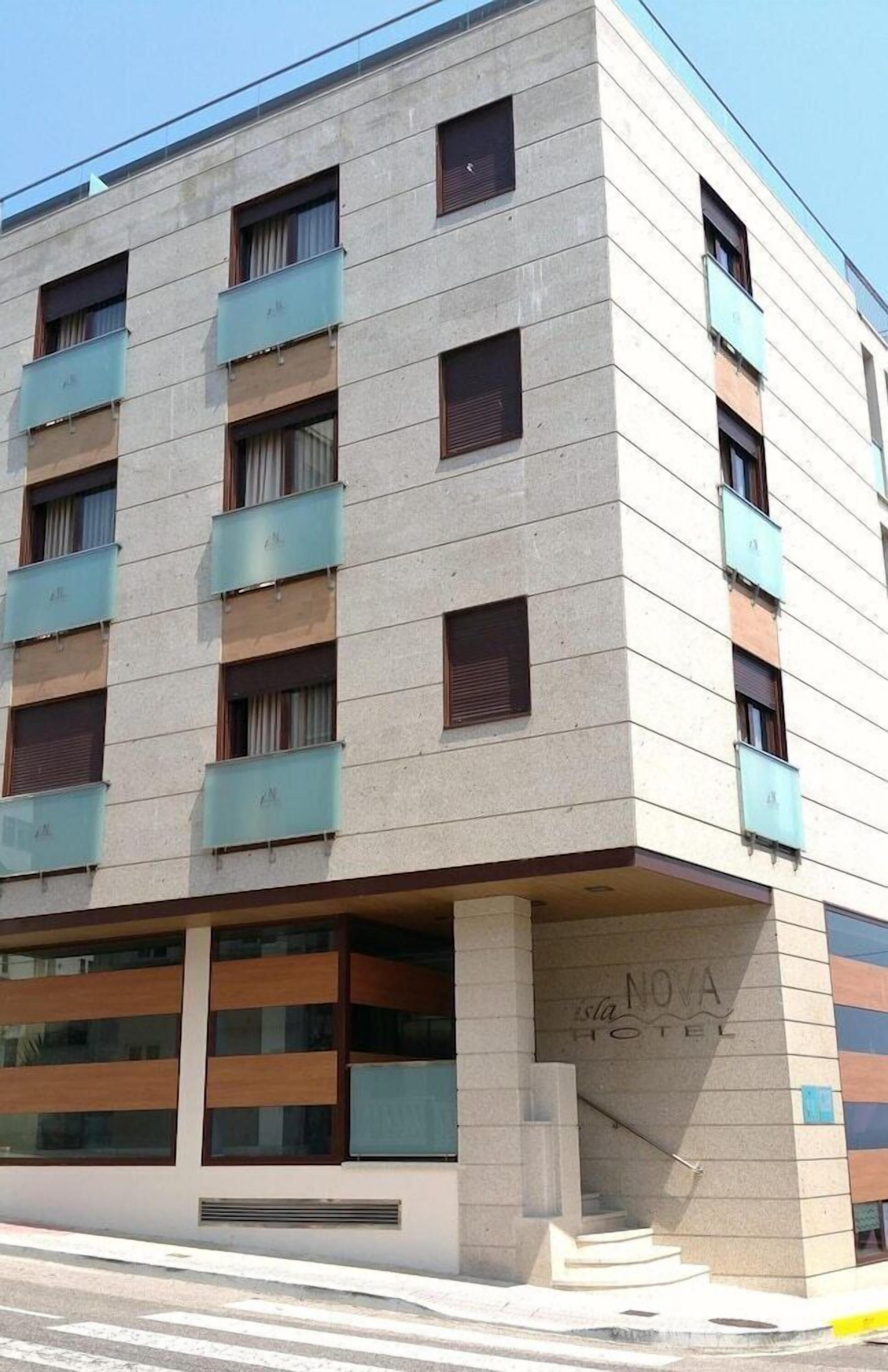 A multi-story hotel with a modern design, featuring balconies and a staircase leading to the entrance.