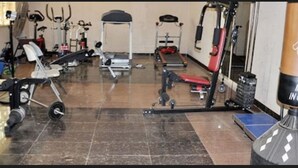 A gym with various exercise equipment including treadmills, weight machines, and a bench. - Keviz Hotel (Lagos)