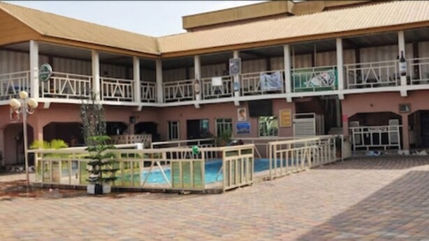 A building with a covered patio area, multiple balconies, and a swimming pool. - Keviz Hotel (Lagos)