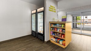 Un espace dédié aux collations, comprenant deux réfrigérateurs, une étagère pour les collations et un panneau mural.