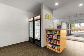 Un espace dédié aux collations, comprenant deux réfrigérateurs, une étagère pour les collations et un panneau mural.
