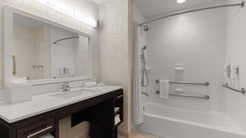 Un bagno moderno con uno specchio grande, due lavandini, una vasca e una doccia.