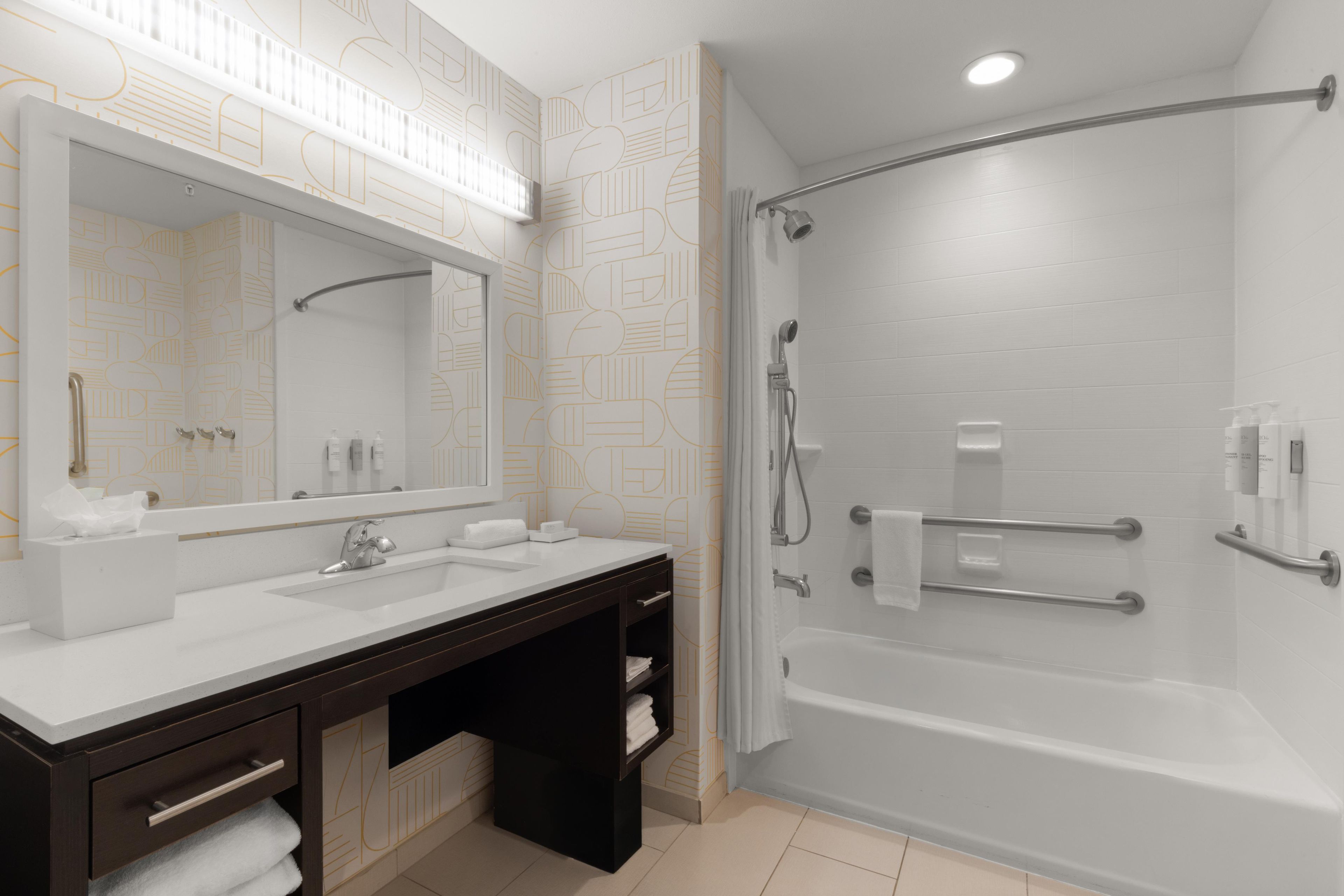 Un baño moderno con un espejo grande, dos lavamanos, una bañera y una ducha.