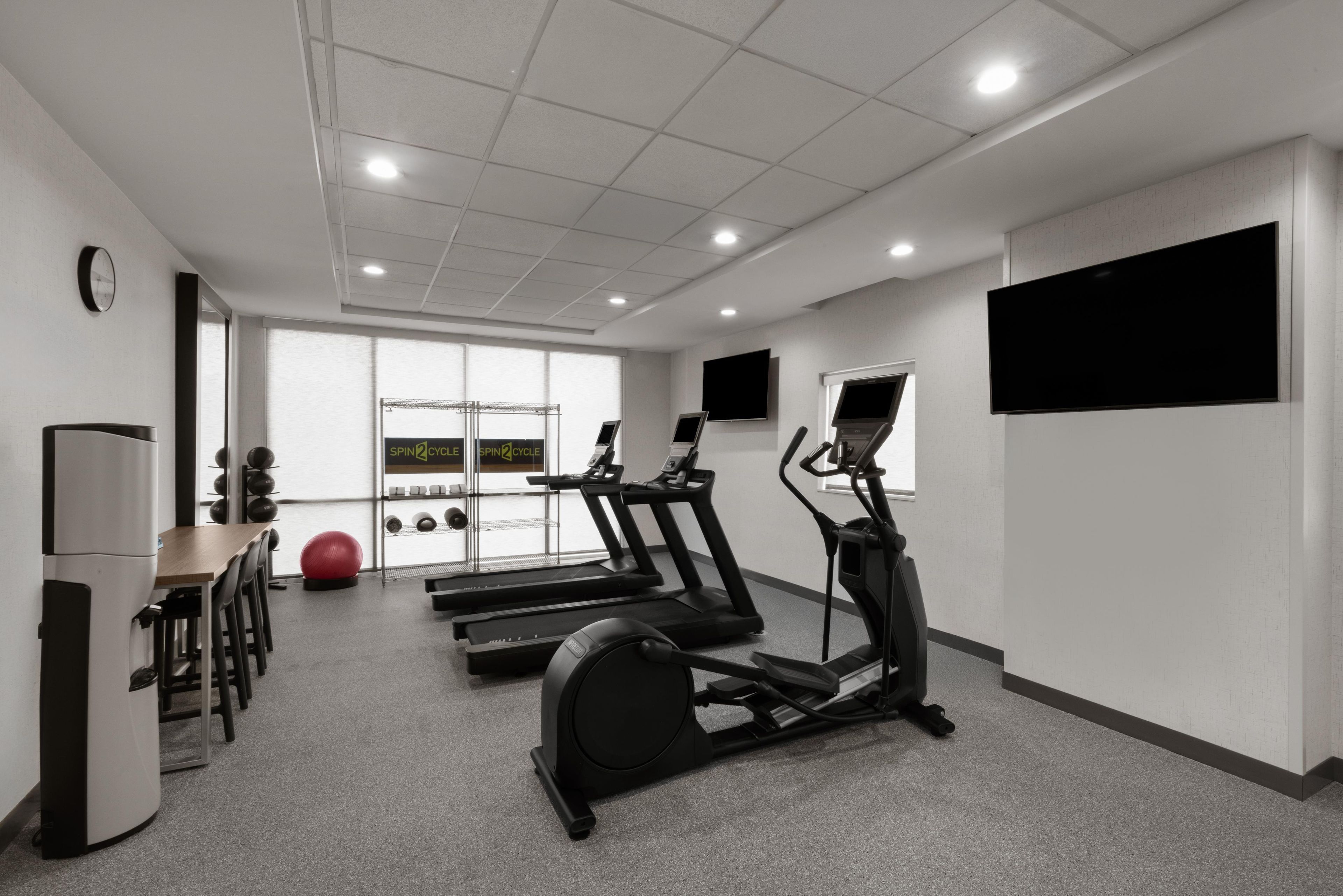 A gym with treadmills, a stationary bike, and exercise balls.