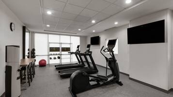 A gym with treadmills, a stationary bike, and exercise balls.