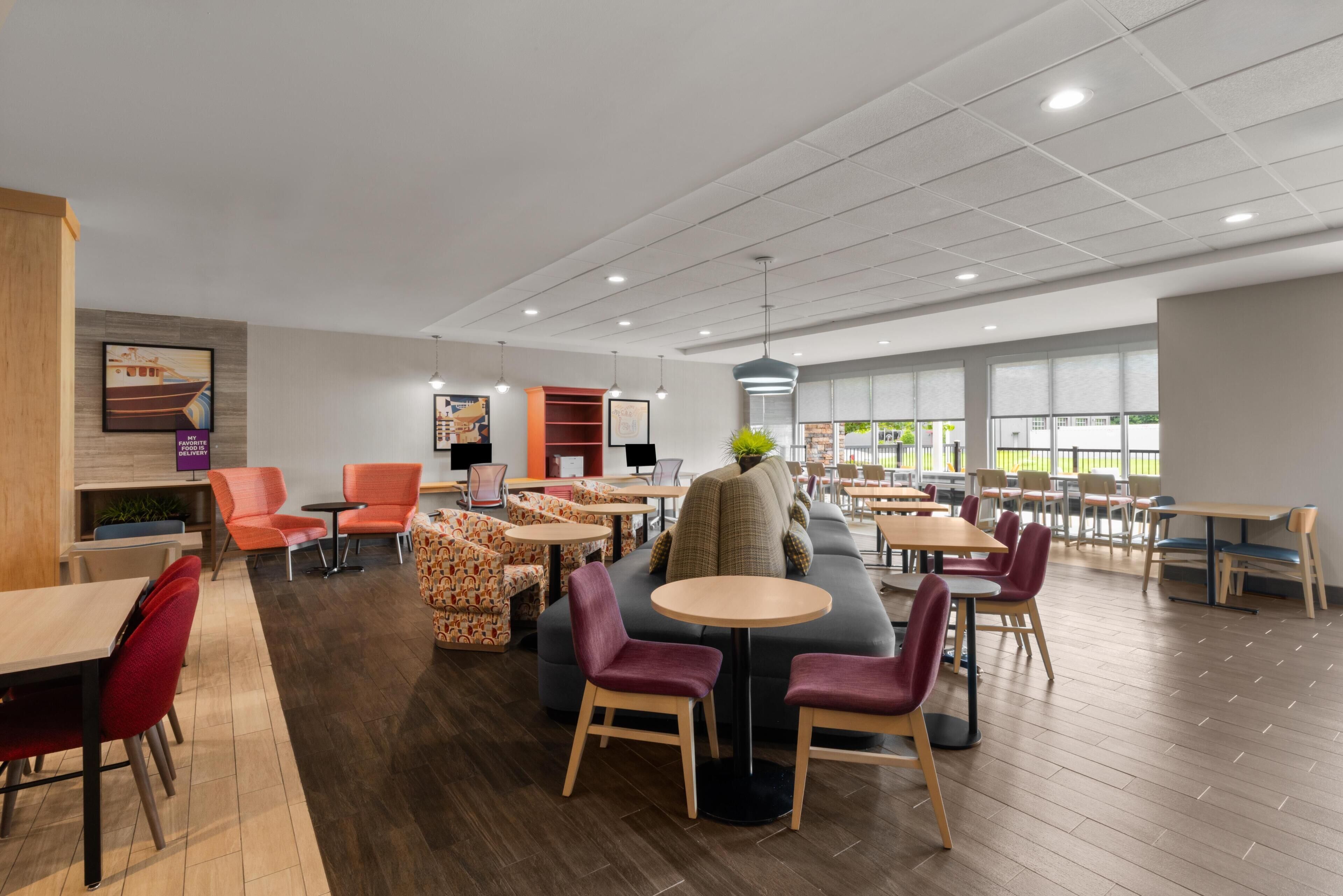 A spacious indoor area with multiple seating options including tables, chairs, and sofas.