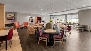 Un espace intérieur vaste et accueillant, offrant de nombreuses possibilités d’assises, notamment des tables, des chaises et des canapés.