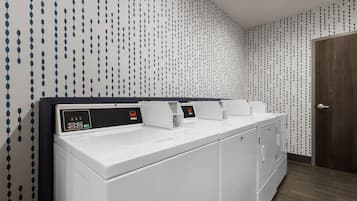 Un baño moderno con un lavabo blanco y un panel de control digital.