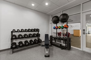 A gym with weightlifting equipment, including dumbbells and kettlebells. - Home2 Suites by Hilton Gonzales, LA (Gonzales)