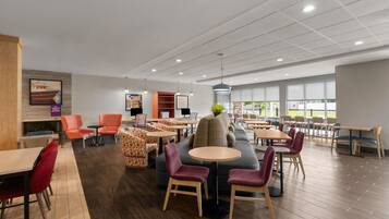 A spacious indoor area with multiple seating options including tables, chairs, and sofas.
