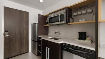 Una cocina moderna con microondas integrado, electrodomésticos de acero inoxidable y lavavajillas.