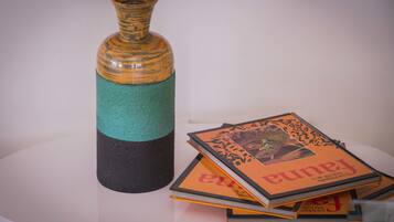 A stack of books with a vase on a table.