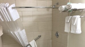 A bathroom with a shower, toilet, and towel rack.