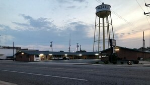 A Haskell Inn with a water tower, a parking lot, and a street view.