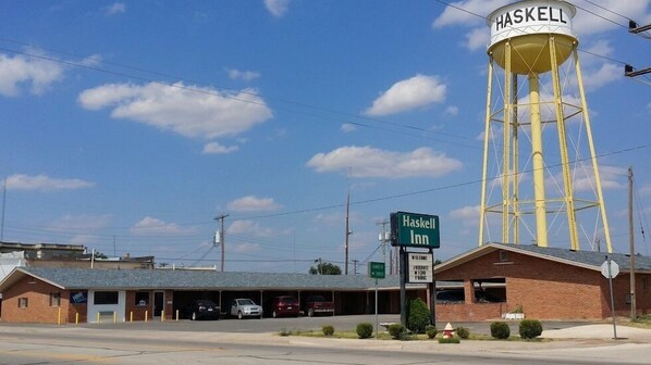A Haskell Inn with a water tower, a parking lot, and a sign indicating the direction to the internet and WiFi.