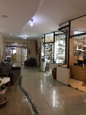 A spacious lobby with a seating area, a glass storefront, and a visible restaurant sign. - Marge Hotel (Aparecida)