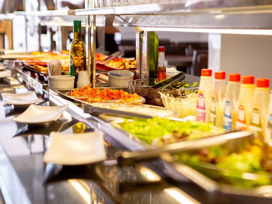 A buffet with various food items and condiments.