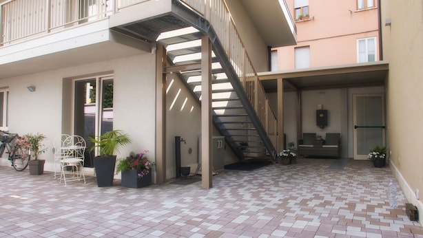 Eine mehrstufige Außenterrasse mit Treppe, Pflanzgefäßen und Sitzbereichen.