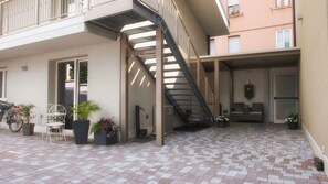 Une terrasse extérieure à plusieurs niveaux, dotée d’un escalier, de plantes en pot et d’espaces aménagés pour s’asseoir.