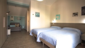 Ein Schlafzimmer mit zwei Betten, einem Schlafsofa und einem kleinen Tisch.