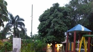 Un espacio al aire libre con césped, una estructura de juegos y una pequeña piscina.
