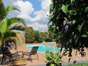 Una piscina al aire libre, sombrillas, tumbonas