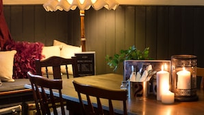 A dining area with a table, chairs, a menu board, candles, and a decorative lamp. - Southern Railway Hotel Goulburn (Goulburn)