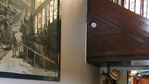 A checkered floor, a vintage sofa, a wall-mounted painting, and a hat rack. - Southern Railway Hotel Goulburn (Goulburn)