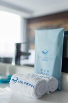 Un asciugamano bianco con il ricamo "AIRLINEINN" e una borsa blu con lo stesso logo.