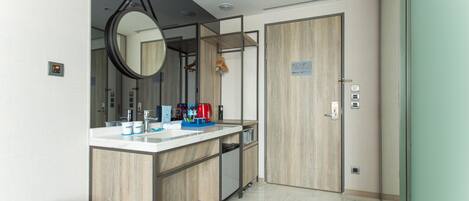 A modern bathroom with a wooden vanity, a mirror, a sink, and a shower area.