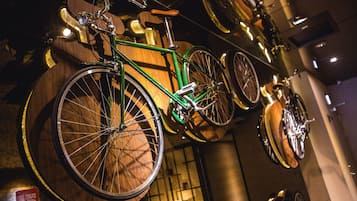A bicycle mounted on a wooden wall with other bicycles.