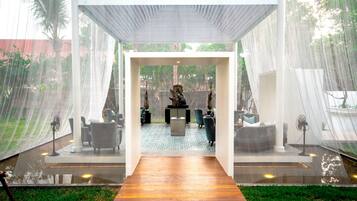A modern indoor space with a wooden floor leading to a seating area with chairs and a table.